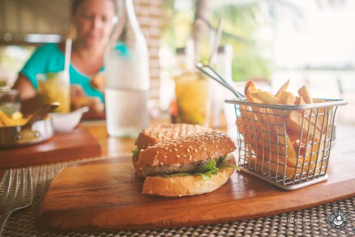 Burger und Pommes auf Holzbrett.