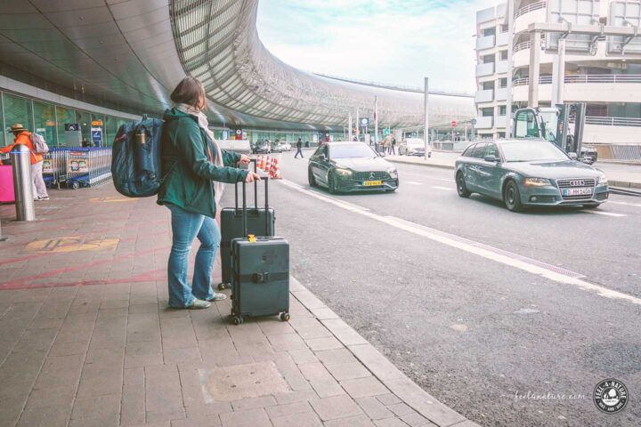 Frau mit Rollkoffern im Abholbereich des DUS Flughafen.