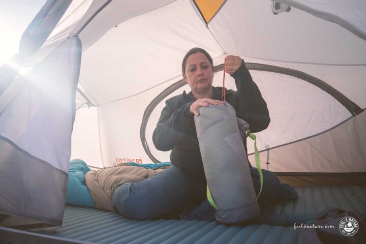 Frau packt Schlafsack im NEMO Aurora Ridge ein.