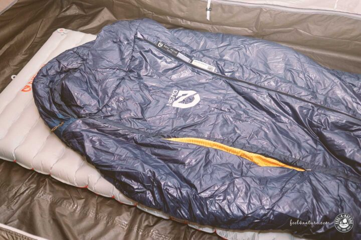 Schlafsack liegt auf Isomatte in Zelt.