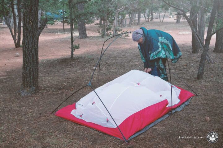 Frau beim Aufbau eines MSR Trekkingzeltes.