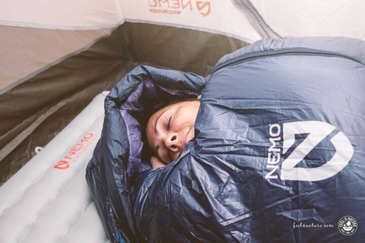 Frau mit Schlafsack auf Tensor All Season Isomatte im Zelt.