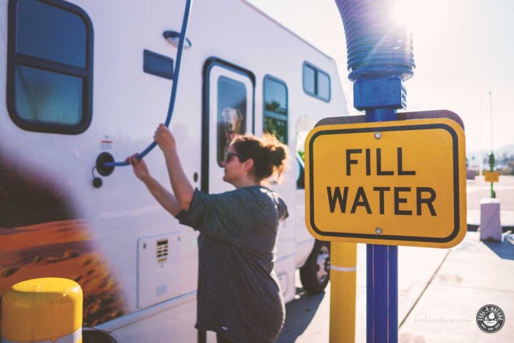 Frau füllt Wassertank des Cruise America C25 Campers.