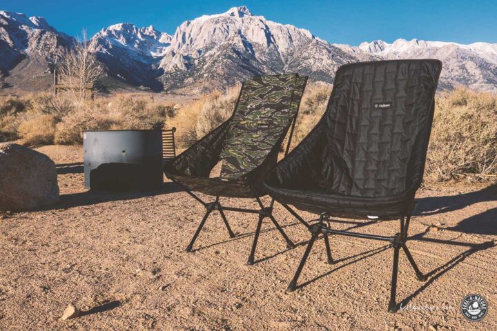 Zwei Helinox Chair One High Back mit Zubehör vor Landschaft.