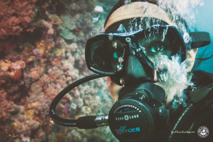 Taucherin atmet mit Atemregler unter Wasser.