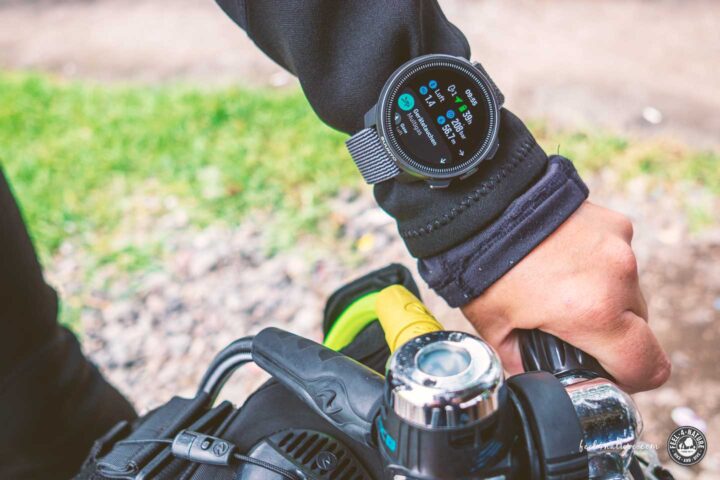 Hand öffnet Ventil von Tauchflasche, Suunto Nautic S zeigt Flaschendruck.