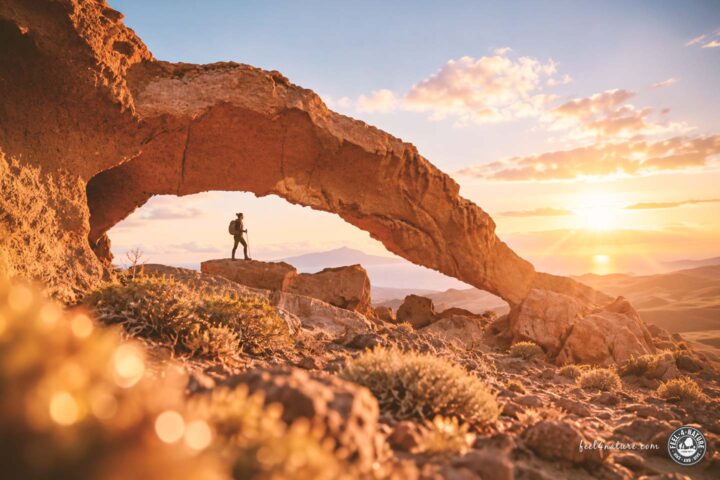 Wanderin steht unter einem Steinbogen auf Teneriffa.